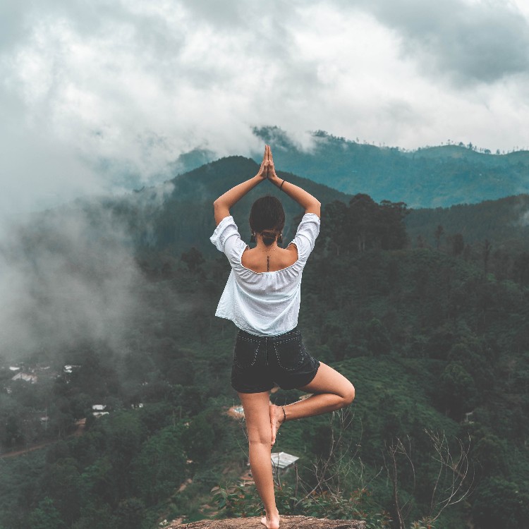 A girl on a mountain in a yoga position.